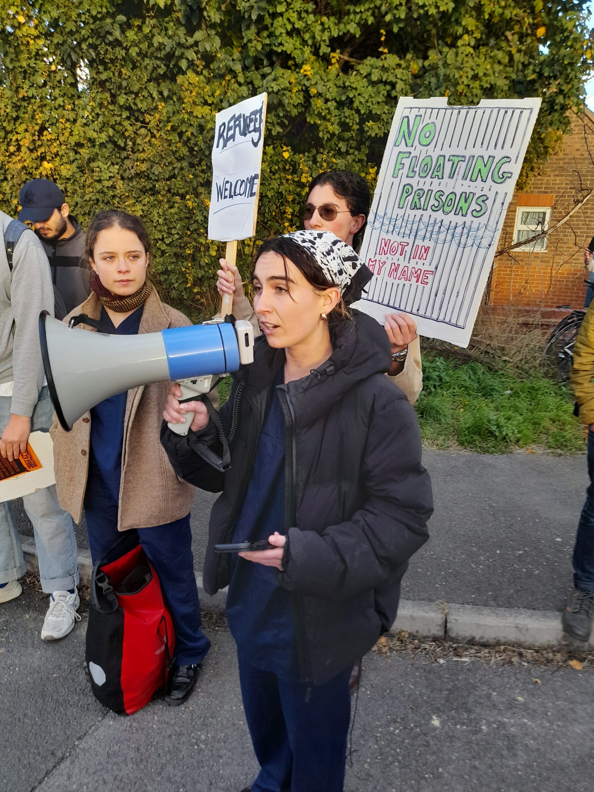 Placard reads "No Floating Prisons - Not In My Name!"