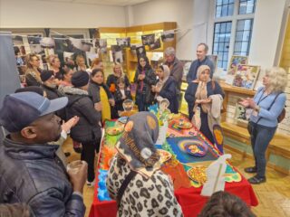 A large of people surrounded by artworks