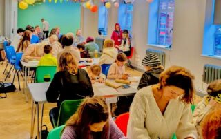 A group of people working on an art project in a relaxed and colourful environment.