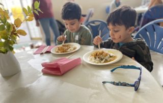 A couple of young children eating.