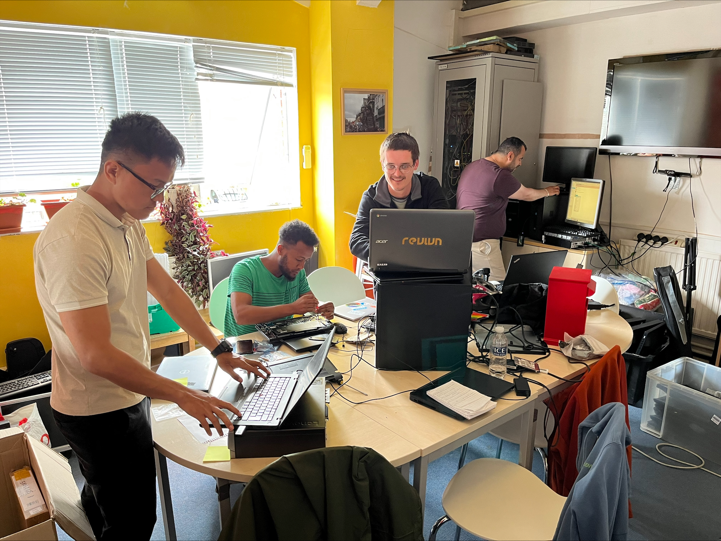 Asylum Welcome volunteers refurbishing laptops.